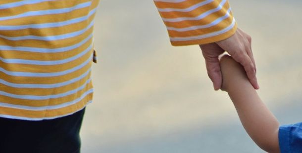 Mamma che tiene per mano un bambino