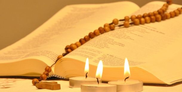 La corona del Rosario a destra, il Vangelo di carta a sinistra